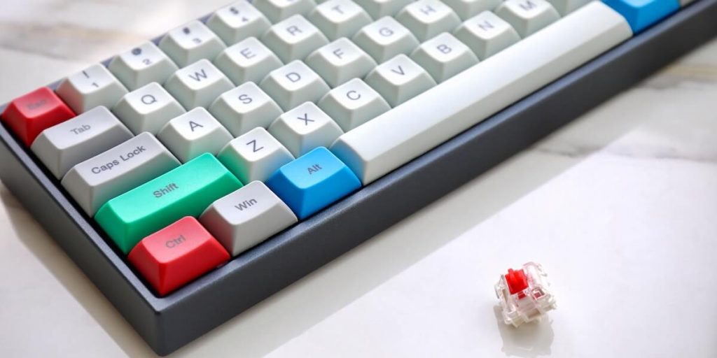 Mechanical keyboard next to a mechanical keyboard switch.