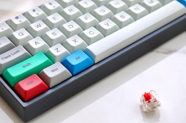 Mechanical keyboard next to a mechanical keyboard switch.