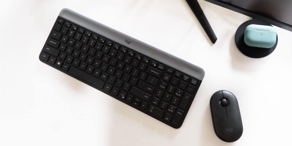 Membrane keyboard on a desk next to a computer mouse.