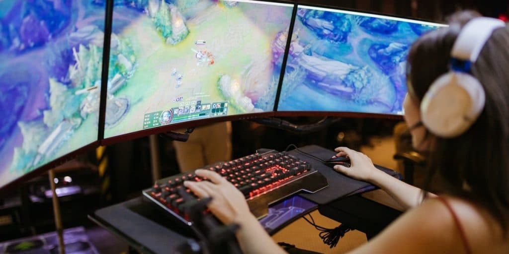 Woman playing league of legends, an MMO, on her mechanical keyboard.