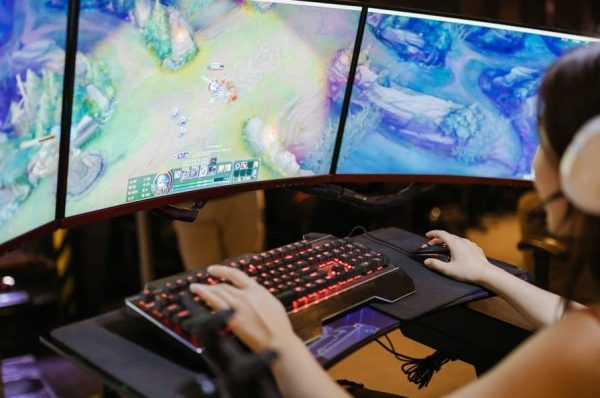 Woman playing league of legends, an MMO, on her mechanical keyboard.