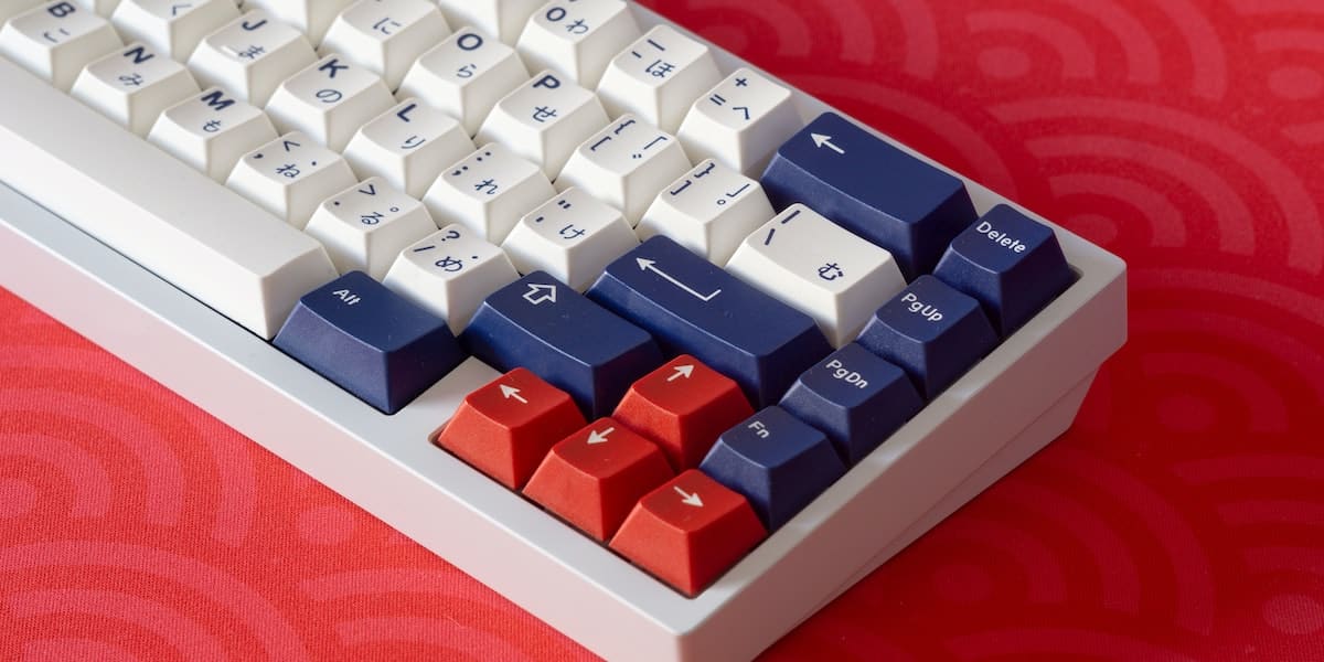 Mechanical keyboard sitting on a red deskmat.